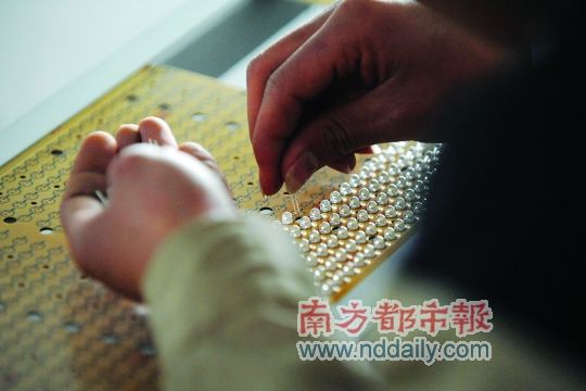 工人忙著安裝用于燈具發(fā)光的LED燈珠，這類工作處于LED燈具生產(chǎn)的最下游。資料圖
